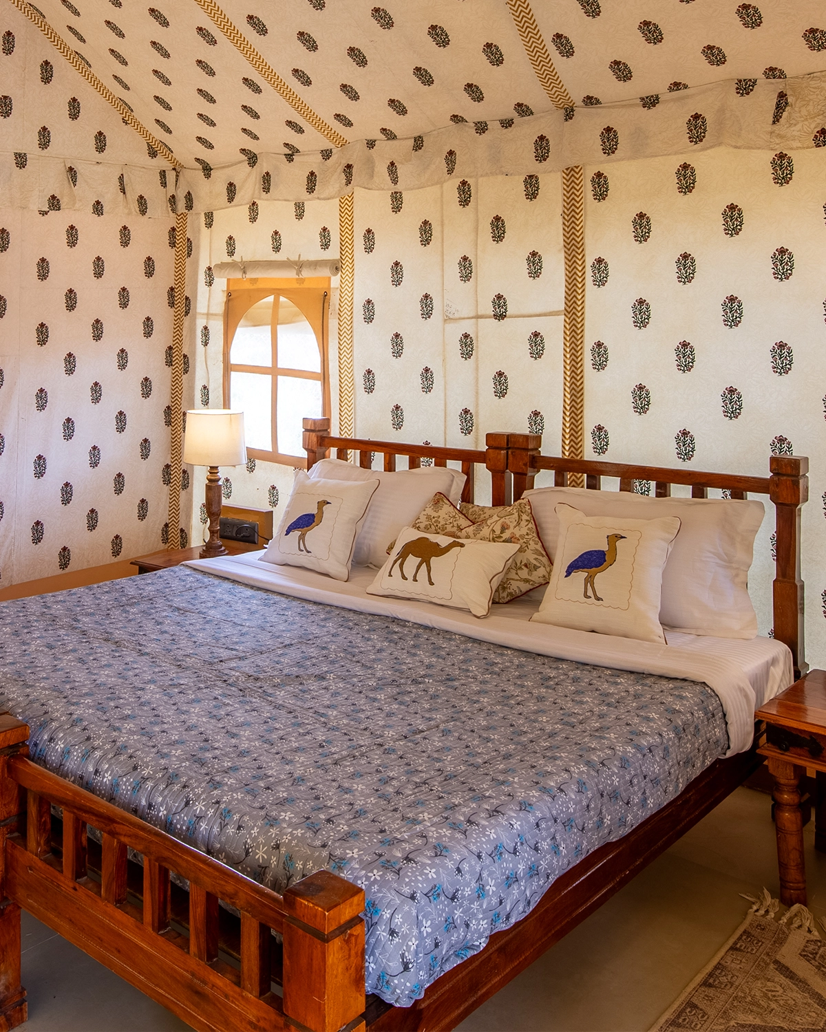 Luxury AC tent interior with carved wooden king bed and block-printed canvas walls